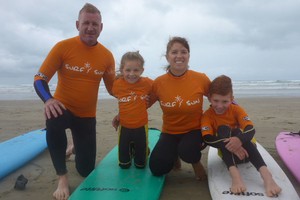 a family pause from their surf lesson for a family photo